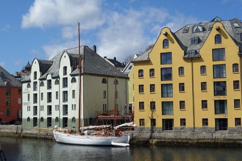 A harbor with a white sailboat docked, colorful buildings, and a clear sky. 2