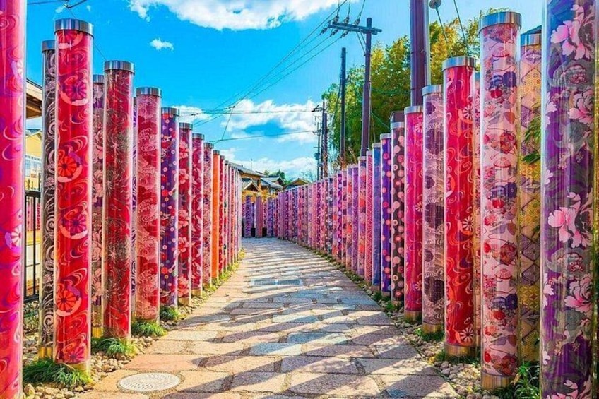 A pathway lined with tall, cylindrical columns adorned with floral patterns. 4