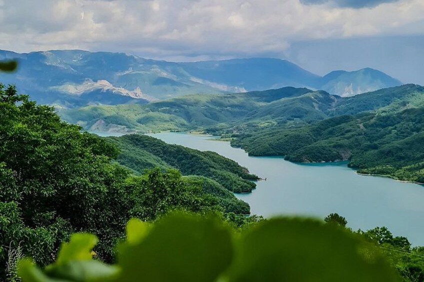 A river winding through a mountainous landscape with dense green foliage. 5