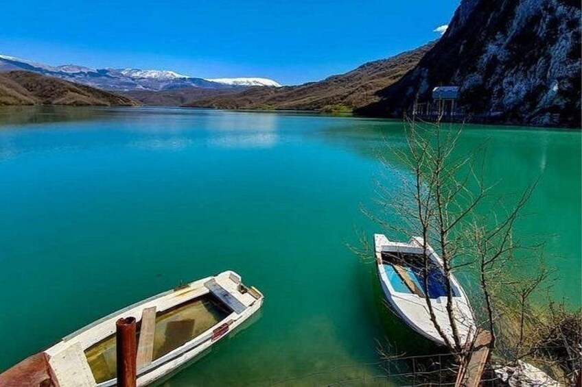 Two boats on a turquoise lake with mountains in the background. 3