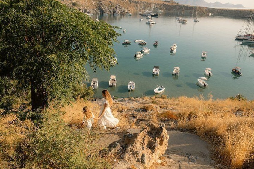 A lake with boats, a tree, and rocky terrain. 1