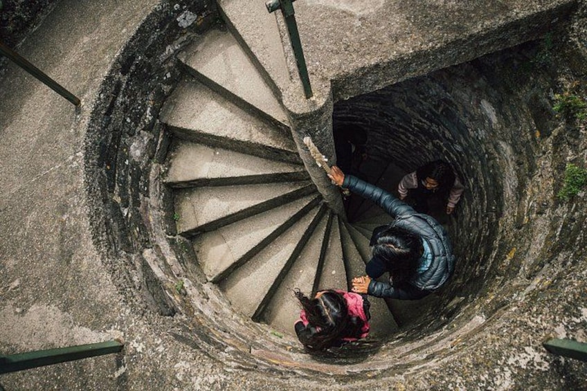 A spiral staircase descending into a dark shaft. 2