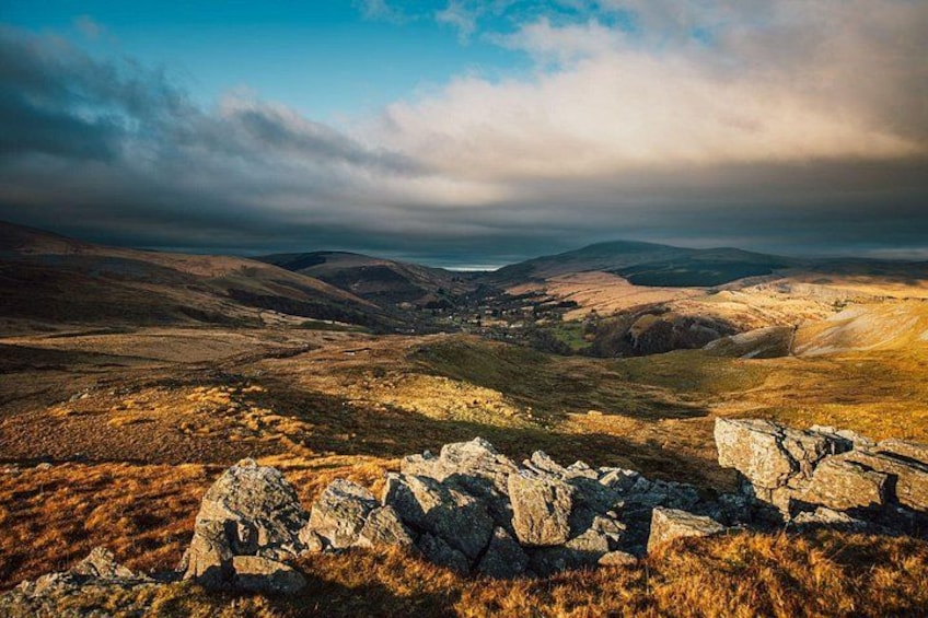 A mountainous landscape with rocky outcrops and a distant view of a valley. 4