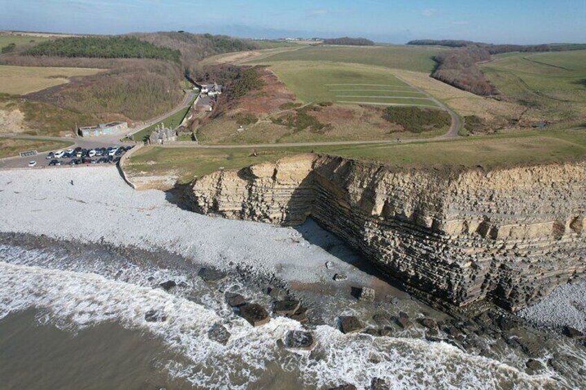 A coastal cliff with a road and buildings in the background. 4