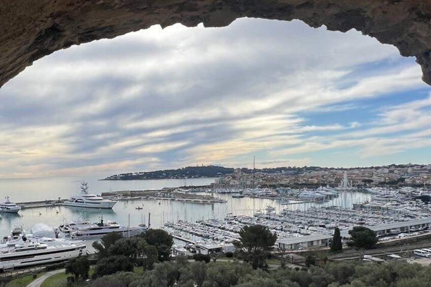 A marina with boats docked, a bridge in the distance, and a cityscape. 2