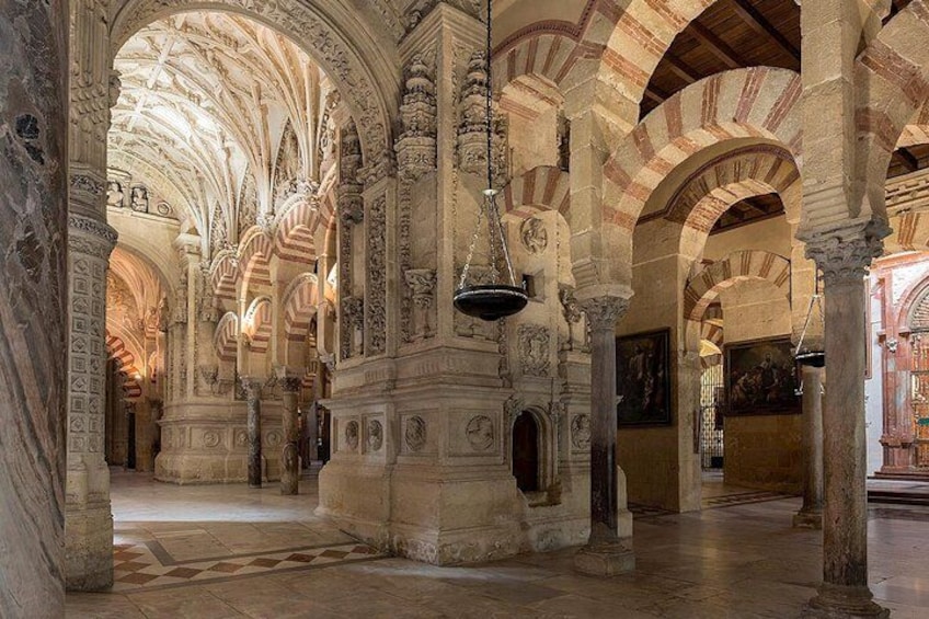 An interior with arches, columns, and detailed carvings. 2