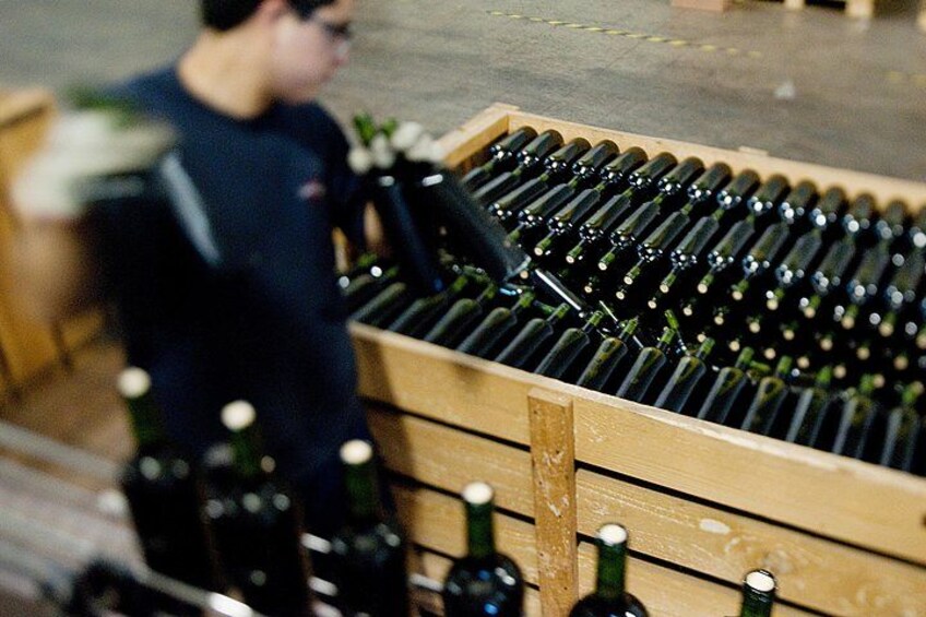 A wooden crate filled with wine bottles. 3