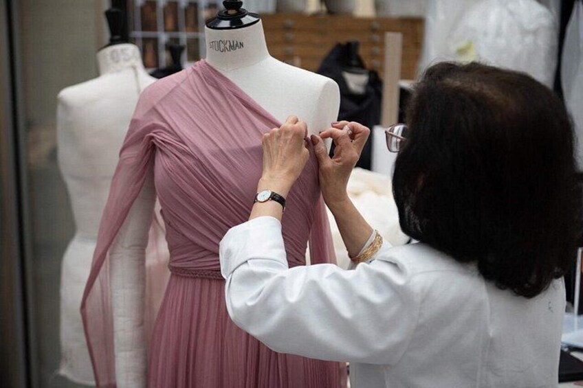 A person adjusting a dress on a mannequin in a clothing store. 4
