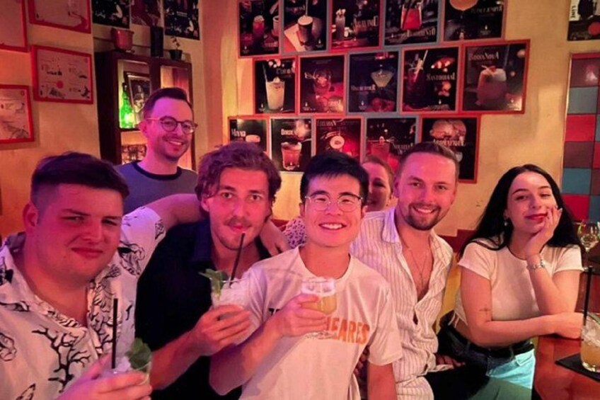 A group of people in a bar with posters on the wall. 2