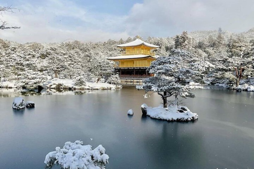 A snow-covered landscape with a traditional building and a pond. 3