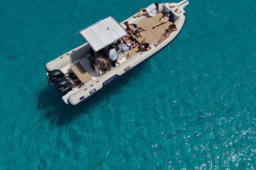 Un petit bateau avec des personnes à bord, flottant sur une eau turquoise et limpide. 5