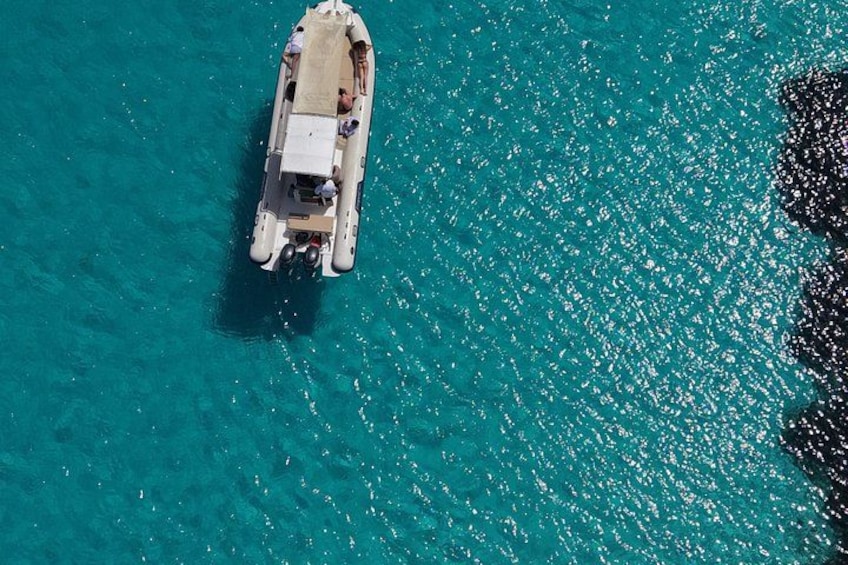 Un petit bateau doté d’un auvent, flottant sur une eau turquoise. 2