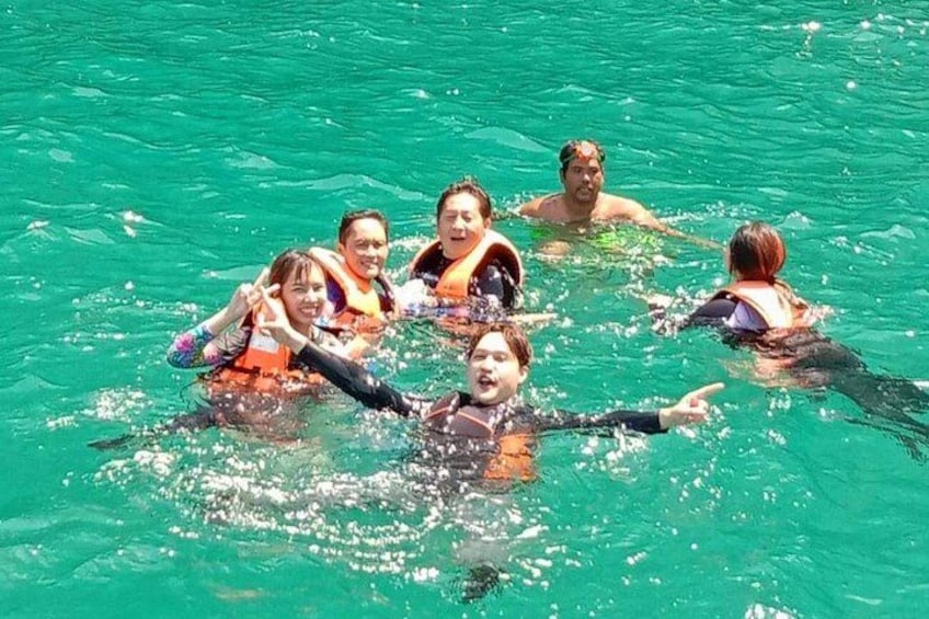 A group of people swimming in clear blue water. 3