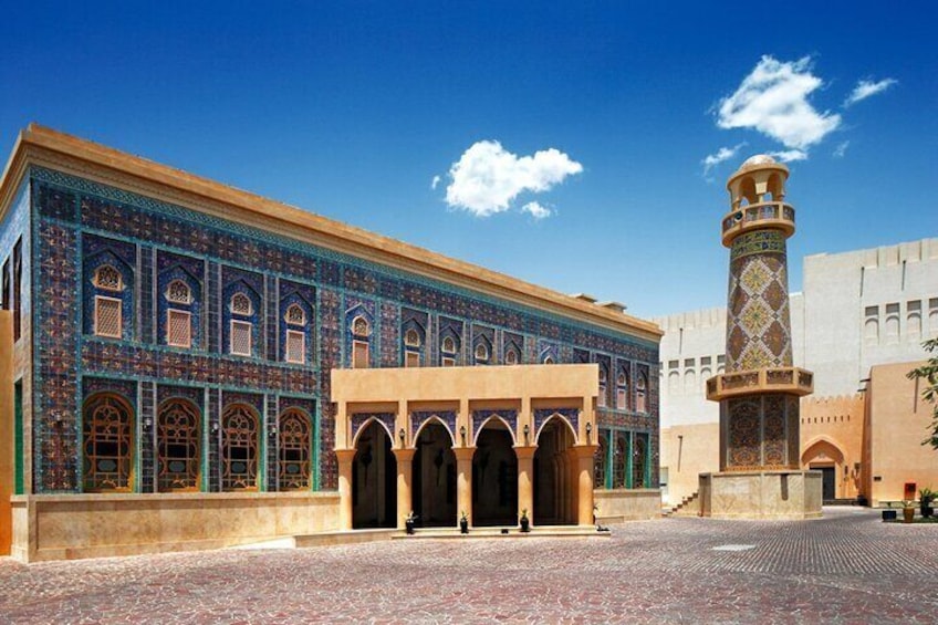En historisk bygning med detaljeret flisearbejde og et højt minaret. 1