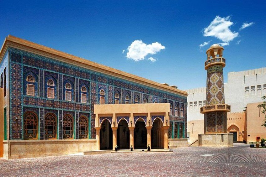Ein historisches Gebäude mit aufwendigen Fliesenarbeiten und einem hohen Minarett. 1