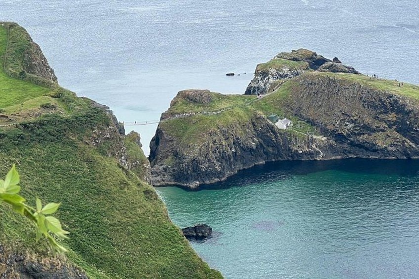 A coastal landscape with grassy cliffs and a narrow waterway. 1