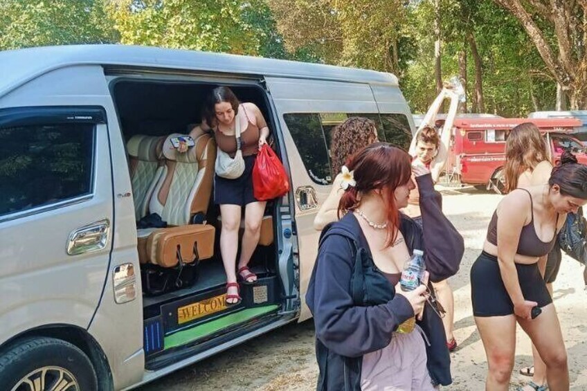 People boarding a van with luggage. 1