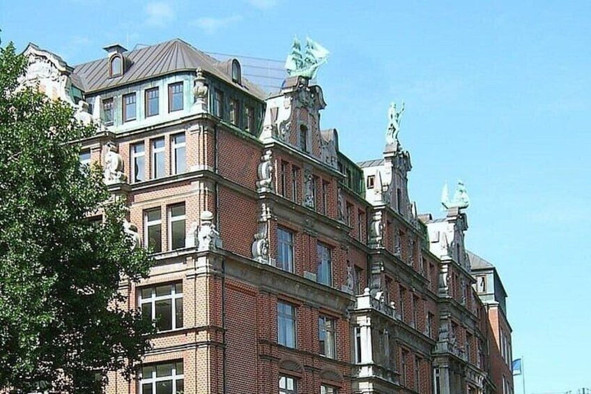 A multi-story building with ornate architectural details, including statues and decorative elements on the roof. 4