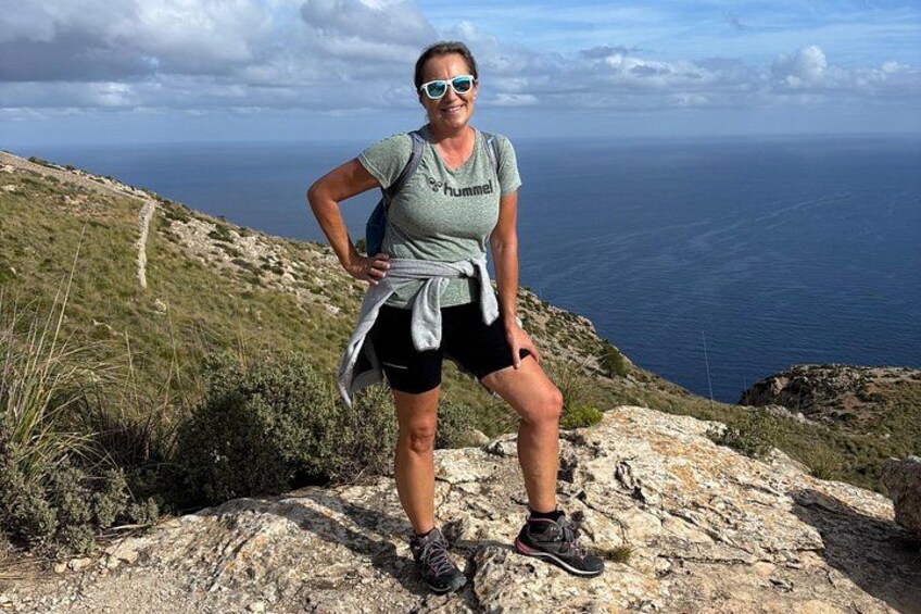 En person står på en klippe med udsigt over havet. 2