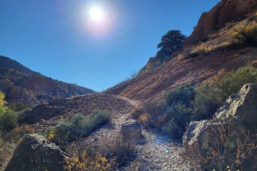 Un canyon rocheux traversé par un cours d’eau étroit, entouré de collines et d’une végétation clairsemée. 2