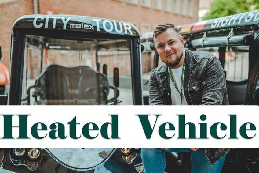 A person sitting in a black City Melex tour vehicle with the text 'Heated Vehicle' on the side. 2