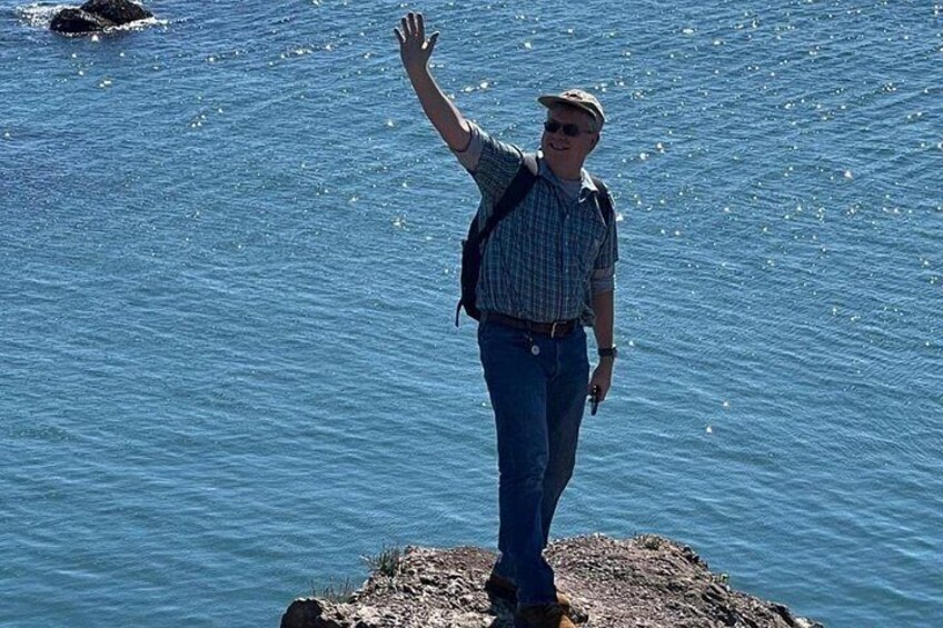 A person standing on a rock by a body of water. 3