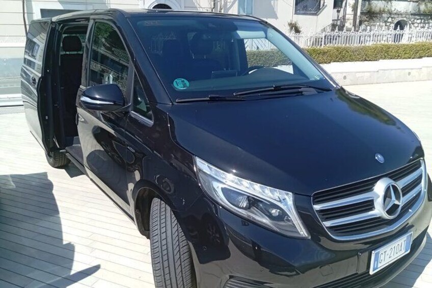 A black Mercedes-Benz van parked on a wooden deck. 2