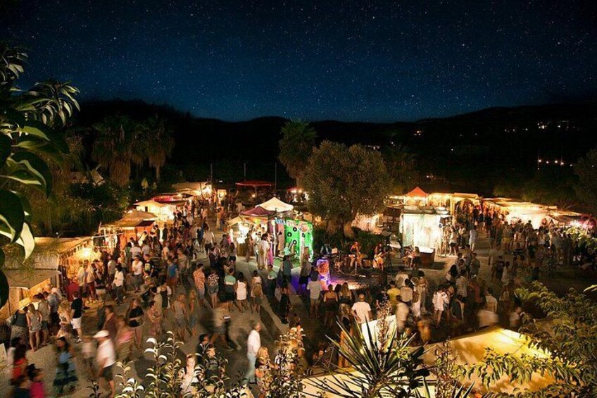 Un événement nocturne en plein air, où les participants se rassemblent autour de stands et de structures illuminées. 3