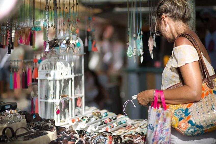 Eine Person betrachtet Schmuck an einem Marktstand. 1