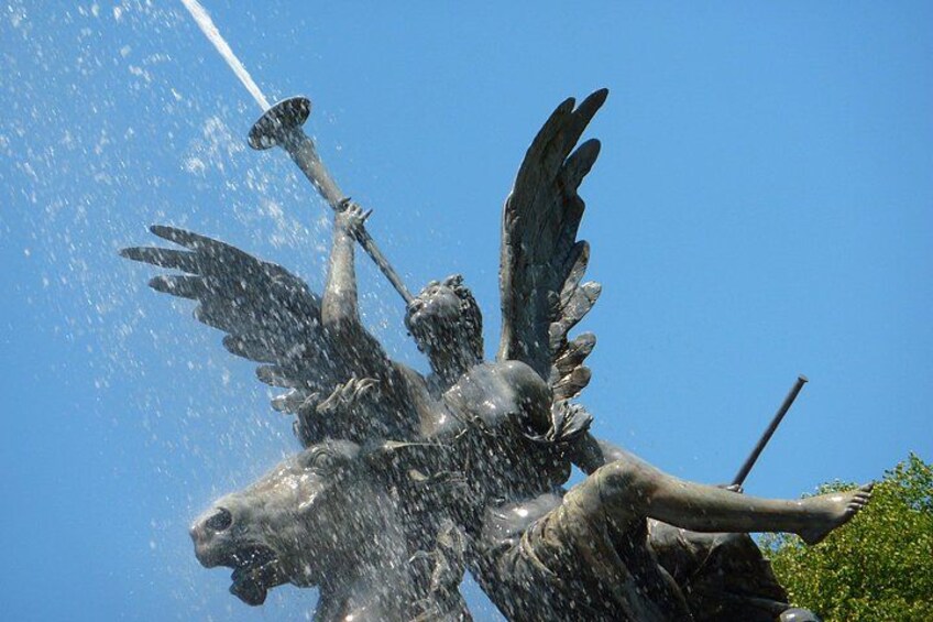 A bronze statue of a winged horse with water spraying from its mouth. 4