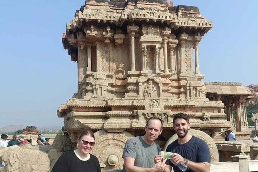A group of people standing in front of a large, intricately carved stone structure. 5