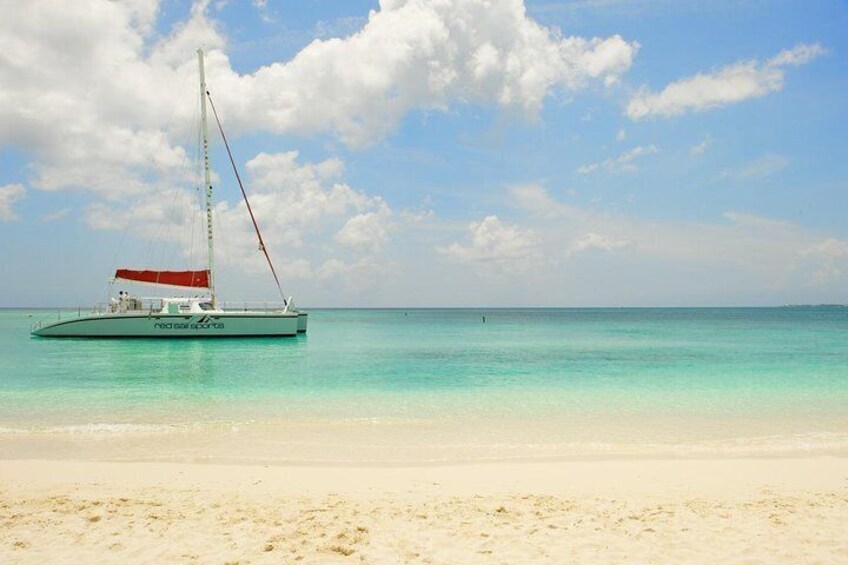 Un voilier sur une eau turquoise, près d’une plage de sable. 5