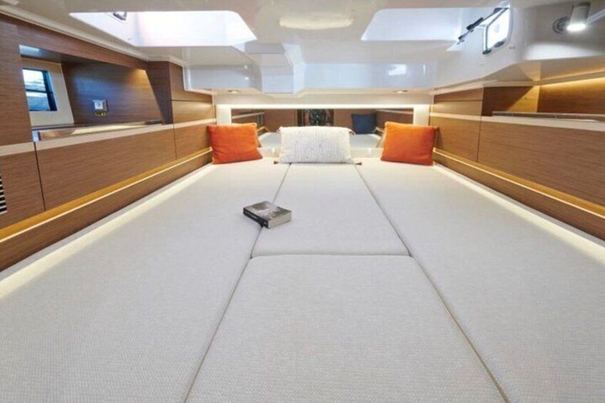 Een modern interieur met een centraal geplaatst bed, houten lambrisering en oranje kussens. 5