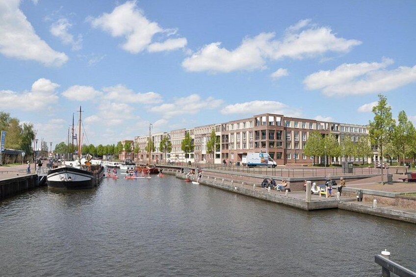 Een gracht met boten, een brug en gebouwen langs het water. 4