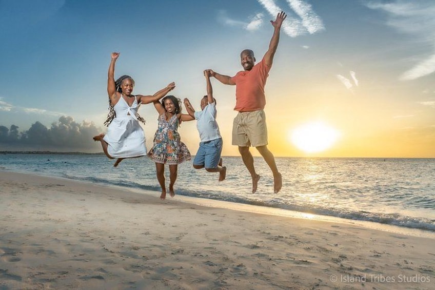 Una playa con gente saltando al aire, el océano y una puesta de sol. 3