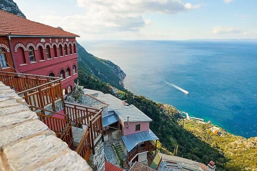 A coastal village with terraced houses, a stone wall, and a view of the sea. 4