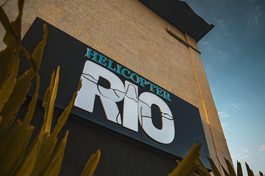 A sign with the words 'Helicopter Rio' on a building. 4