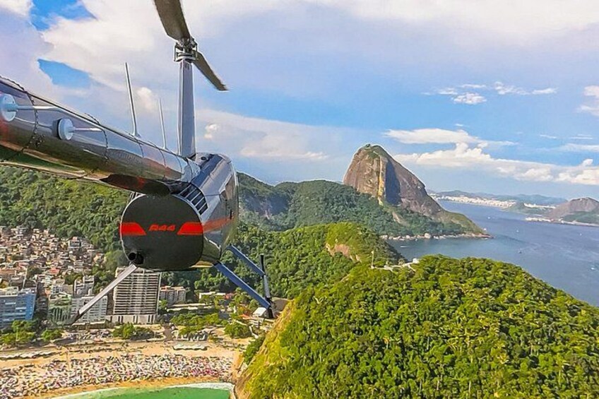 A helicopter flying over a city with a prominent mountain in the background. 5