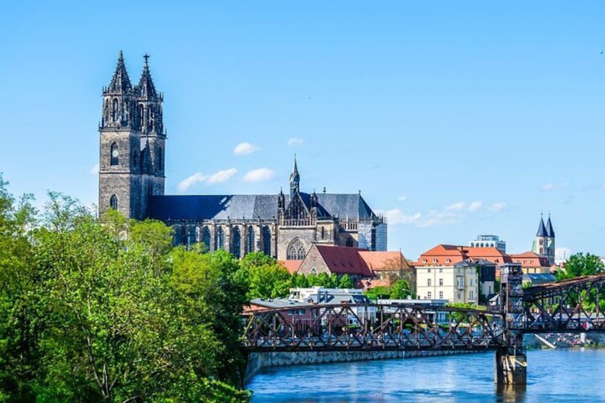 Une église historique dotée d’un clocher imposant, un pont et une rivière. 1