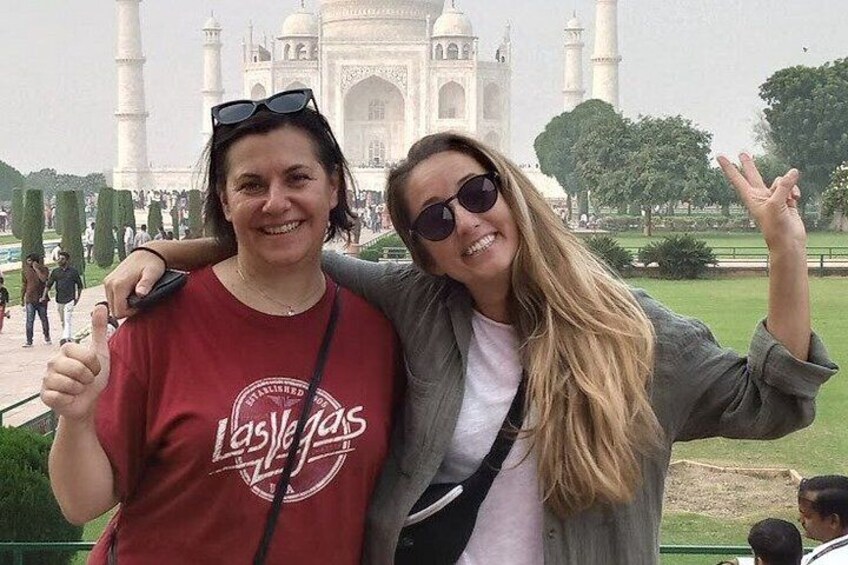 Dos personas posando frente al Taj Mahal, con el monumento al fondo. 4