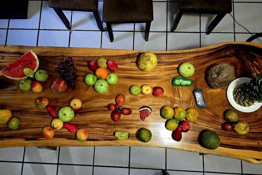 A wooden table with various fruits and a bowl of pineapples. 3