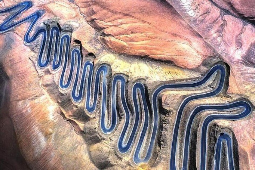 A geological formation with winding striations and layered rock structures. 1