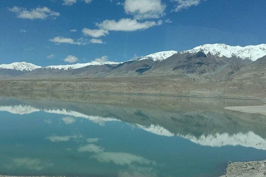 A calm lake reflecting mountains and a clear sky. 4
