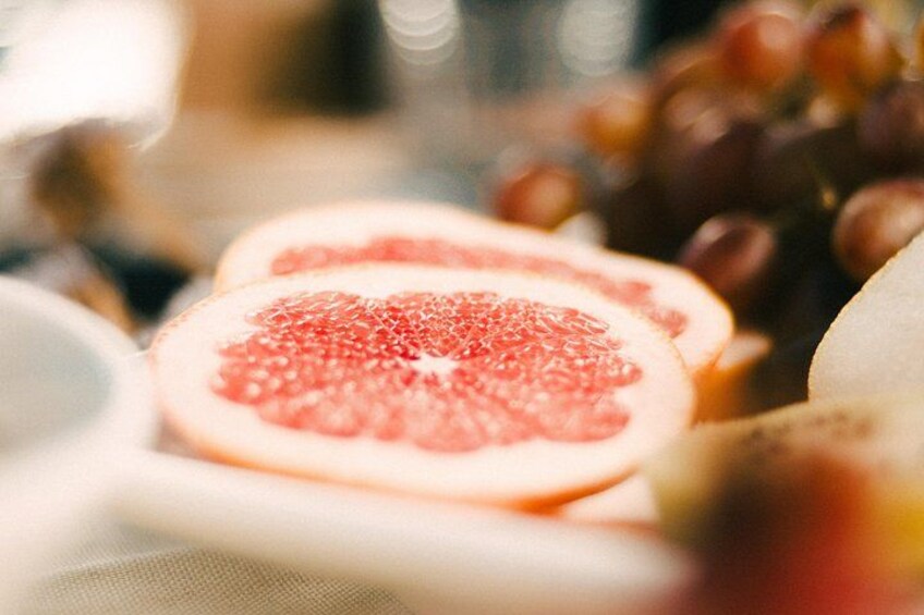 Detailaufnahme einer angeschnittenen Zitrusfrucht, vermutlich einer Grapefruit, wobei der saftige Innenraum hervorgehoben wird. 4