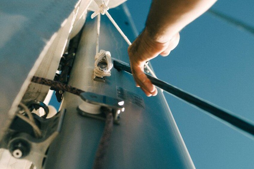 A hand adjusting a metal rod on a structure. 2