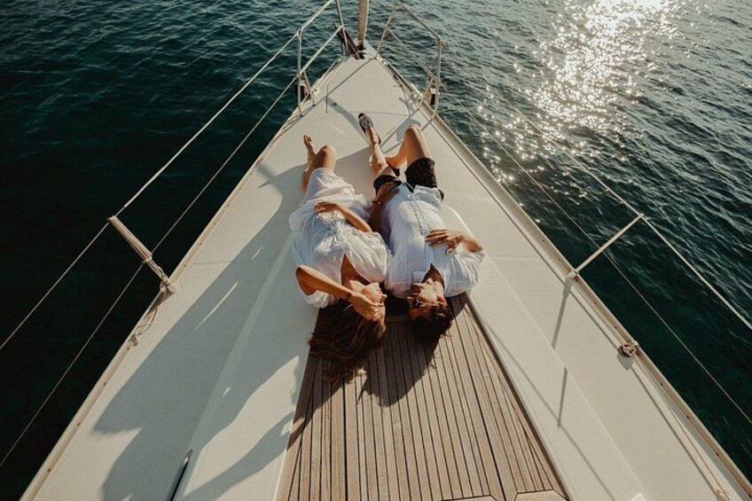 Ein Paar liegt auf dem Deck eines Bootes, im Hintergrund das Meer. 3