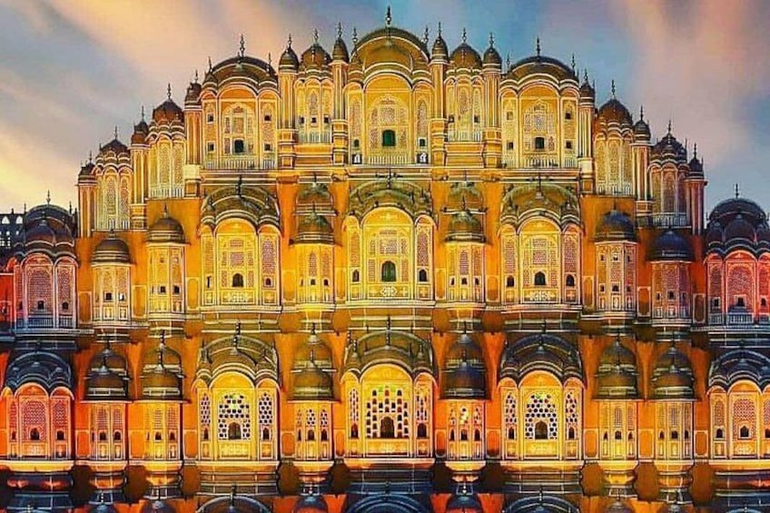 Un edificio luminoso y ricamente decorado con cúpulas y arcos múltiples, reflejado en el agua. 2