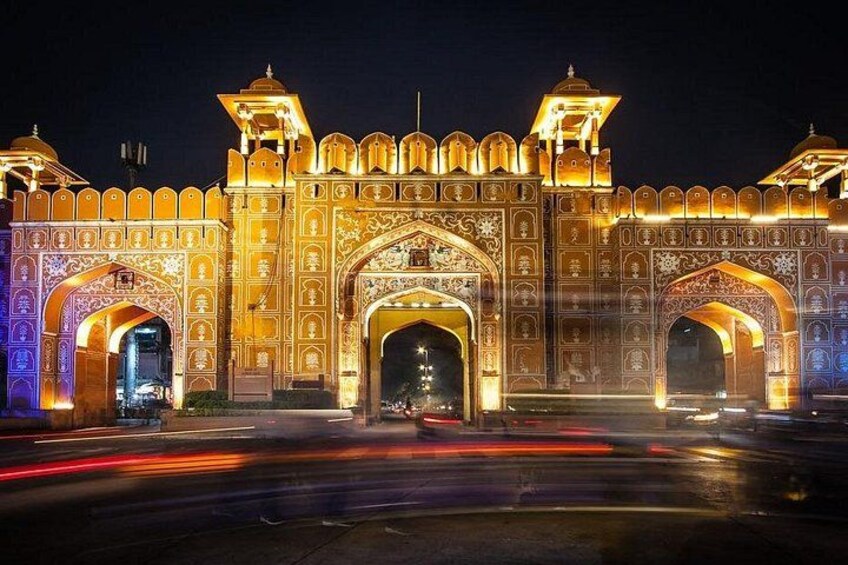Una puerta histórica, luminosa, con diseños intrincados y dos torres. 5