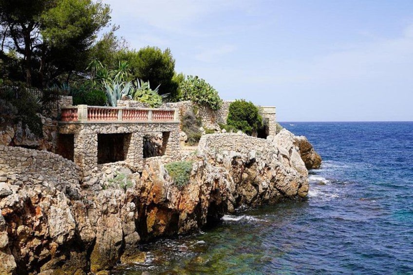 A coastal stone structure with a balcony overlooking the sea. 2