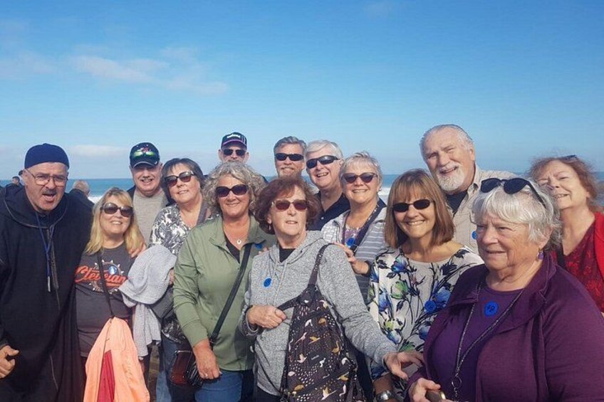 A group of people standing on a beach with the ocean in the background. 2